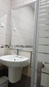 uma casa de banho branca com um lavatório e um espelho em Villa Bratislava em Demir Kapija