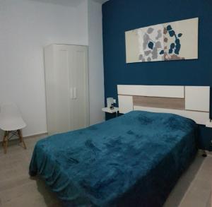 - une chambre bleue avec un lit et un mur bleu dans l'établissement La Naval 209, 5ºA - LONDRES -, à Las Palmas de Gran Canaria