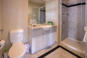 a bathroom with a toilet and a sink and a shower at Flinders Landing Apartments in Melbourne