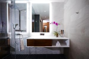 a bathroom with a tub, sink and mirror at Le Germain Hotel Toronto in Toronto