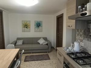 a kitchen and a living room with a couch and a table at Le Casette di Nonna Rosa in Fontanarossa Catania Airport in Catania