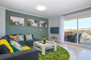 a living room with a couch and a table and a tv at Dúplex Moreras del Saladar in Jávea