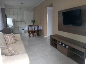 a living room with a couch and a flat screen tv at Casa 2 quartos - São Bernardo in São Francisco de Paula