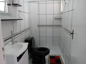 a bathroom with a black toilet and a sink at Casa 2 quartos - São Bernardo in São Francisco de Paula +13 photos