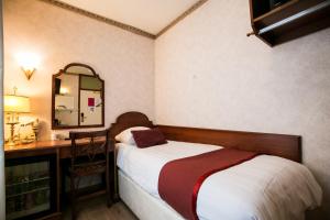 アムステルダムにあるホテル アトランタのベッドルーム(ベッド1台、デスク、鏡付)