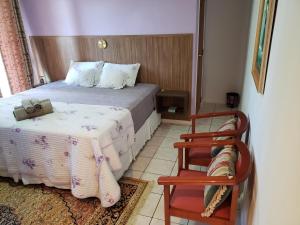 um pequeno quarto com uma cama e uma cadeira em Hostel Equilíbrio em Florianópolis