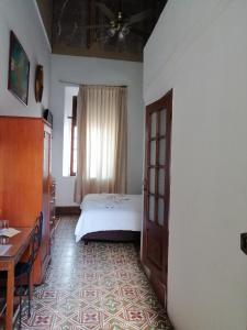 a bedroom with a bed and a table and a window at Hotel Reforma in Mérida