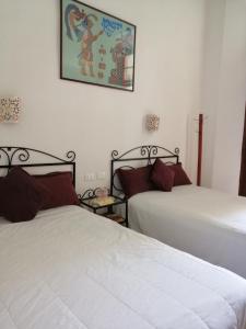 1 dormitorio con 2 camas y una foto en la pared en Hotel Reforma en Mérida