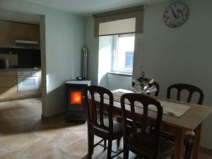 una sala da pranzo con tavolo, sedie e piano cottura di Casa do Sapateiro a Sobral de São Miguel