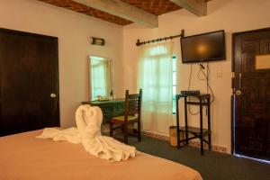 a bedroom with a bed with a towel on it at Hotel Parador del Cortijo Spa in San Miguel de Allende