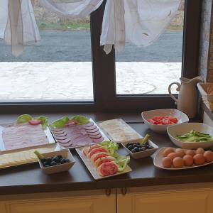 a table with different types of food on a counter at Pensiunea Oana ☆☆☆ in Şoimuş