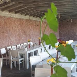 uma sala de jantar com mesas brancas e cadeiras brancas em Pensiunea Oana ☆☆☆ em Şoimuş