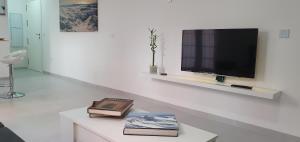 Una sala de estar con un televisor en una pared blanca. en ecoSmart Apartments, en Granada