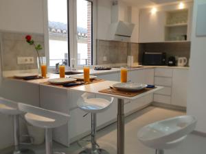 una cocina con mesa con sillas y velas de naranja en ecoSmart Apartments, en Granada 16 fotos más