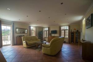a living room with two chairs and a couch and a table at Quinta da Ribeira in Peso da Régua