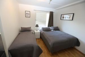 two beds in a small bedroom with a window at OSLO CITY CENTER 3 BEDROOMS APARTMENT, MANDALLS GATE 12 in Oslo