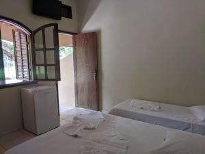 a bedroom with two beds and a door with a window at Pousada Canto do Rio in Três Marias +50 photos