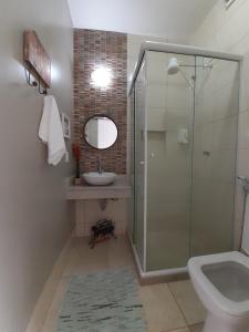 a bathroom with a shower and a sink and a toilet at Pousada Vila Flor in Rio das Flores
