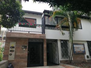 une maison avec un palmier en face dans l'établissement apartamentos casa Margarita en laureles estadio su hogar en Medellin, à Medellín