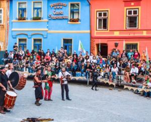 un grupo de personas de pie delante de una multitud en Casa Saseasca, en Sighişoara