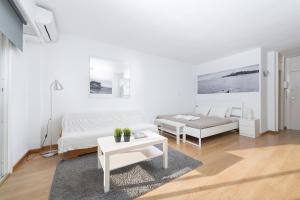 a white bedroom with a bed and a table at Nice Studio in Siesta 2 in Puerto Alcudia 4 in Alcudia