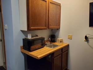 
a kitchen with a stove top oven and microwave at Budget Host Inn Fridley in Fridley
