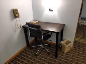 
a desk with a chair and a lamp at Budget Host Inn Fridley in Fridley
