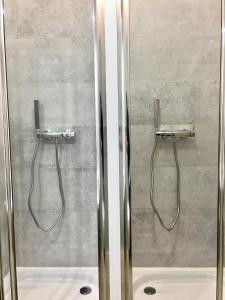 two shower stalls in a bathroom with chrome fixtures at Fractal Guest Rooms - Poznań Centrum Andersia Square & Old Town in Poznań