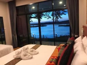 a bedroom with a large window with a view of the water at Khong Chiam Orchid Riverside Resort in Khong Chiam