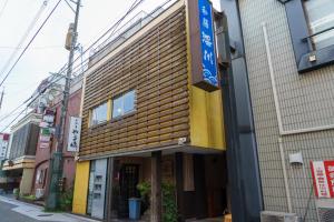 un edificio con facciata in legno su una strada di ゲストハウス さんかくワサビ a Saiki