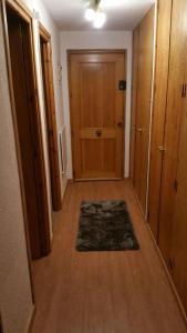 a hallway with a wooden door and a rug at estudio con vistas in Sierra Nevada
