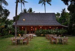 a group of tables and chairs in front of a building at Kayumanis Jimbaran Private Villas & Spa in Jimbaran