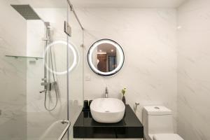 Baño blanco con lavabo y espejo en Hanoi Exclusive Hotel, en Hanói
