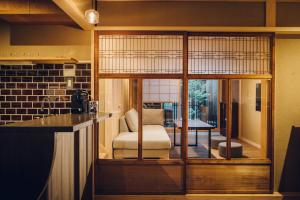 a kitchen with a glass door with a chair and a table at Someno House Kyoto Dog Friendly in Kyoto