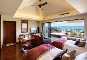 a hotel room with two beds and a balcony at THE HIRAMATSU HOTELS & RESORTS GINOZA OKINAWA in Ginoza