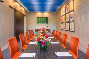 a long table with orange chairs and a vase of flowers at Holiday Inn Express & Suites - Tampa North - Wesley Chapel by IHG in Wesley Chapel +33 photos