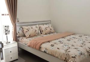 a bedroom with a bed and a night stand at Villa Blossom Kayana Regency E7 in Batu