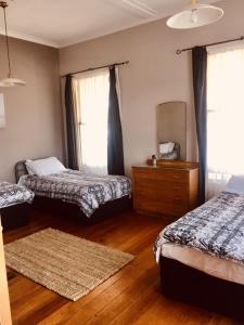 1 Schlafzimmer mit 2 Betten, einer Kommode und einem Spiegel in der Unterkunft HarbourView Hotel in Raglan