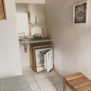 a kitchen with a sink and a small refrigerator at Pousada Bar Café Algas Marinhas in Praia do Forte