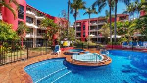 a swimming pool in front of a building at Enderley Gardens Resort in Gold Coast