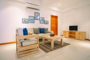 sala de estar con sofá, mesa y TV en Oceanfront Condominiums - Nilaveli, en Nilaveli