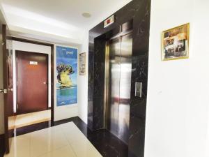 a elevator in a building with a sign on the wall at Homestay Kuching Hotel in Kuching