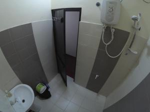 a small bathroom with a toilet and a shower at Kandy Backpackers Hostel in Kandy