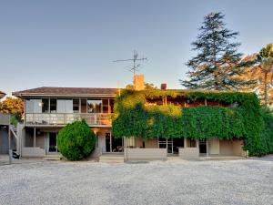 un edificio cubierto de hiedra verde en una calle en Dutchies Motel Nelson Bay & Dutchmans Beach Apartments, en Nelson Bay