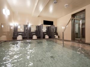 uma piscina num quarto de hotel com banheira em Green Rich Hotel Kurashiki Ekimae (Artificial hot spring Futamata Yunohana) em Kurashiki