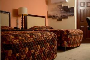 une chambre d'hôtel avec deux lits, une table et une lampe dans l'établissement DURAZNO INN, à Nuevo Casas Grandes