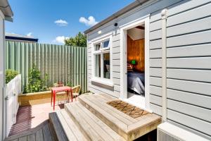 a tiny house with a porch and a patio at Ahuriri Studio Cottage in Napier