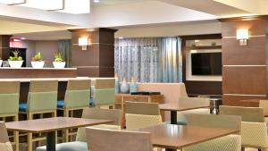 um restaurante com mesas e cadeiras e uma televisão de ecrã plano em Holiday Inn Express and Suites Schulenburg, an IHG Hotel em Schulenburg