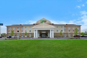 a large building with a lawn in front of it at Holiday Inn Express & Suites Utica by IHG in Utica
