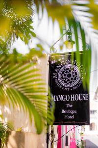 un panneau indiquant une maison de mangrove à côté d'un palmier dans l'établissement Mango House - Galle Fort, à Galle